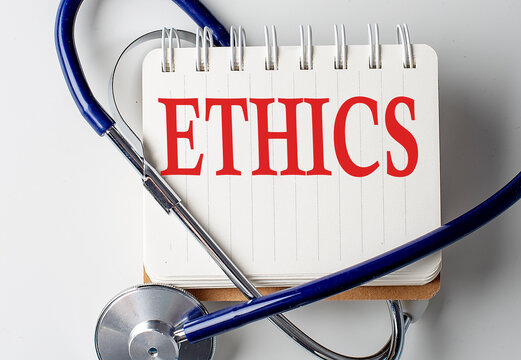 ETHICS word on notebook with medical equipment on background