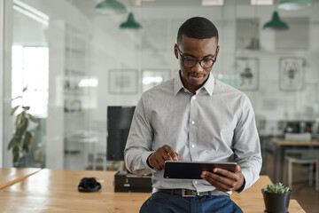 African businessman working on a tablet in a modern office