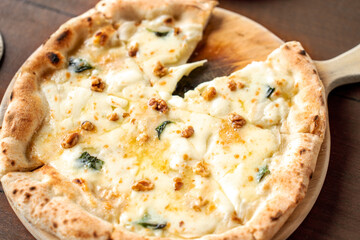 Pizza quattro fromaggi on a wooden board. Four Cheese Pizza or Quattro Formaggi Pizza topped,...