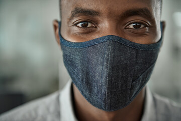 African businessman wearing a protective face mask in his office