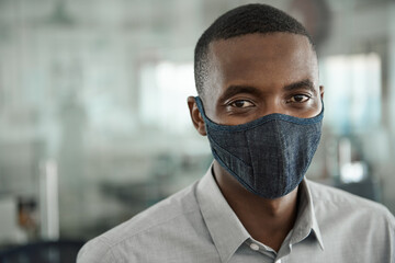 Young African businessman wearing a protective face mask at work