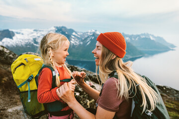 Mother traveling with daughter child family happy laughing together outdoor hiking in Norway healthy lifestyle backpacking in mountains active vacations woman with kid Mother's day holiday - obrazy, fototapety, plakaty