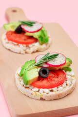 Rice Cake Sandwiches with Avocado, Tomato, Cottage Cheese, Olives and Radish on Wooden Cutting Board. Easy Breakfast. Diet Food. Quick and Healthy Sandwiches. Crispbread with Tasty Filling