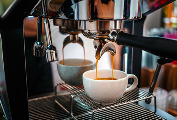Coffee extraction from the coffee machine with a portafilter pouring coffee into a cup,Espresso pouring from the coffee machine at coffee shop