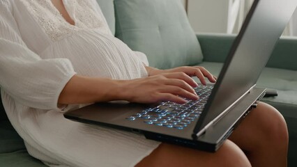 Midsection shot of unrecognizable pregnant woman working on laptop placed on laps doing paperwork at home.. Pregnant woman working at computer. Freelance and remote work. - Powered by Adobe