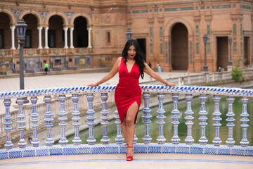 Young and beautiful brunette and latin woman, dressed in short red dress and red shoes visits the...