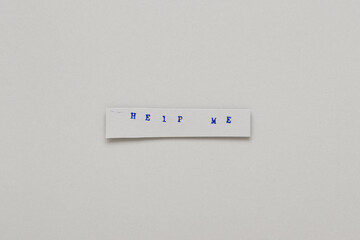Words help me printed on paper in blue ink.