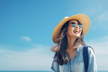Happy young Asian tourist woman wearing beach hat, sunglasses and backpacks going to travel on holidays on blue background. - Powered by Adobe