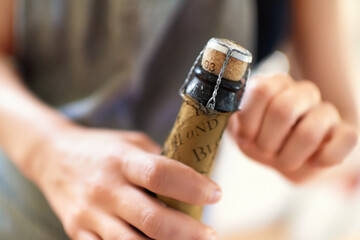 Hands, person and open cork on bottle of wine, champagne and alcohol for party, celebration and...
