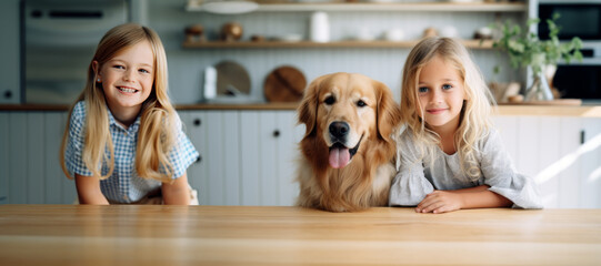 Two beautiful little girls posing with a golden retriever dog at the kitchen table. Cute babies and their pet preparing for breakfast at home. Happy sisters and puppy enjoy their time spent together. - obrazy, fototapety, plakaty