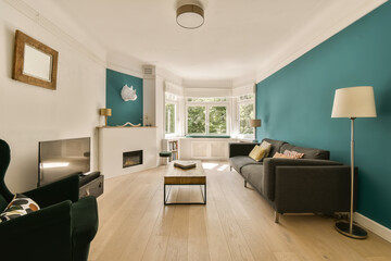Fototapeta na wymiar a living room with teal blue walls and white trim on the walls, hardwood flooring is light wood
