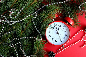 The red alarm clock is on a red background with Christmas decorations.