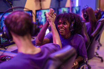 A pair of young multiracial players shake hands to celebrate the start of the online tournament.