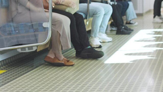 Inside a modern subway carriage, the selective focus 4K on the floor with copy space, where passenger shadows cast by the windows seeing movement. It shows concept of urban lifestyle in Japan.