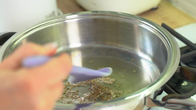 In a frying pan with GHI oil, mix cumin seeds. Cooking food.