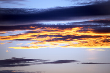 Picturesque view of orange sky with dark clouds in sunset time. Textured background of beautiful sunset. Beautiful background blur.