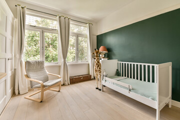 a baby's room with a cribt and a rocking chair in front of the window looking out