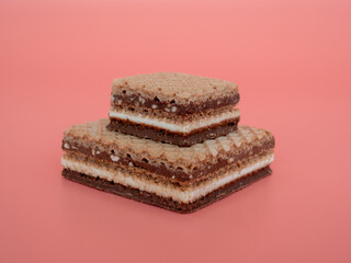 Delicious chocolate wafers with hazelnuts on a pink background. Wafers with chocolate and nuts.