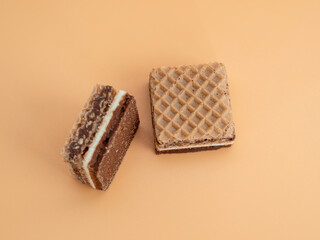 Delicious chocolate waffles with hazelnuts on an orange background. Wafers with chocolate and nuts.
