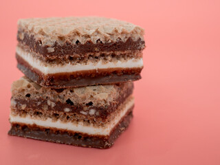 Delicious chocolate wafers with hazelnuts on a pink background. Wafers with chocolate and nuts.