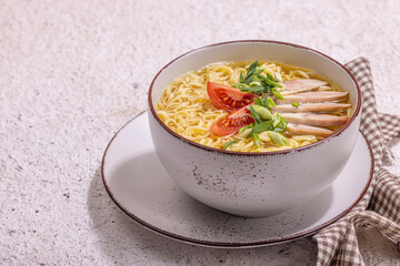 Spicy noodles with beef broth. Hot dish, cutlery, hard light, dark shadow. Stone concrete background