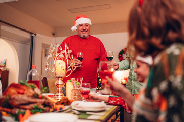 Group of happy family smiling happy celebrating christmas toasting with wine. Family member enjoy home made turkry grill dining togather at home. Christmas and New Year interior concept.