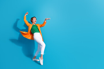 Full body cadre of orange jacket elegant expensive style glamour clothes dance girl look empty space isolated on blue color background