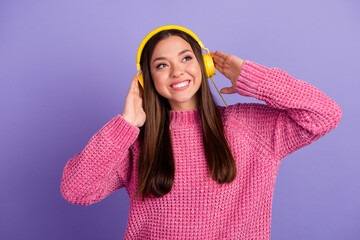 Funny young asian woman in casual clothes cap posing isolated on purple background studio portrait. People lifestyle concept. Mock up copy space. Listening music with headphones, dancing