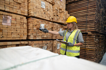 Warehouse staff verify wooded pallets items using handheld device, ensuring precise shipment.