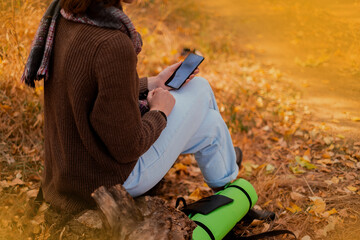 Tablet, backpack and woman traveling in nature in the forest in search of adventure, weekend trip...