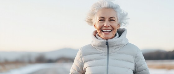 active senior woman running out running outdoors in winter and smiling happily - obrazy, fototapety, plakaty