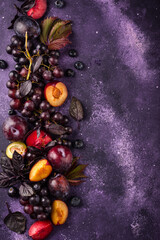 Assortment of purple fruit plum, grape, blueberry and basil