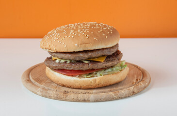 Double cheeseburgers isolated on white table with orange background 