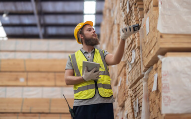 Warehouse staff verify wooded pallets items using handheld device, ensuring precise shipment.