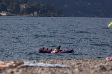 Fototapeta premium woman sunbathing and relaxing on a floating mat