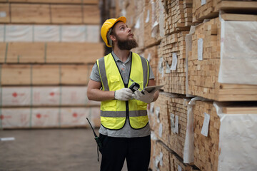 Warehouse staff verify wooded pallets items using handheld device, ensuring precise shipment.