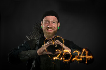 Schornsteinfeger in Arbeitskleidung formt mit Händen Herz und lacht, Symbolbild Jahreswechsel 2024.