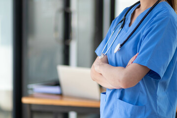 medical professional or doctor stands inside doctor office preparing to check on patients at...