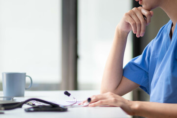 female doctor is reviewing documents to review and diagnose illness and female doctor has...