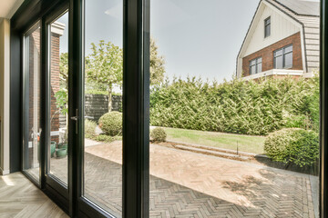 an outside area that looks very nice with the sun shining through the sliding glass door to the yard and garden