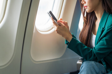 Fototapeta premium Female airplane passengers asian chinese people Entrepreneurs on Flight, Venturing Overseas Investments. Global Business Expansion, Foreign Markets, Strategic Financial Moves. Women in Business Suits