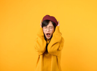Feeling the noise stress. A frustrated woman, in a yellow sweater and red beret, covers her ears...