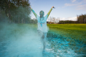 Portrait of happy European woman celebrating Holi with powder colors or gulal.