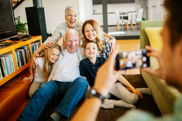 Happy multigenerational family getting their picture taken in the living room
