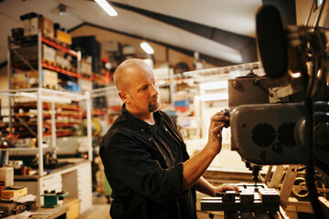 Middle aged engineer working in a mechanic factory