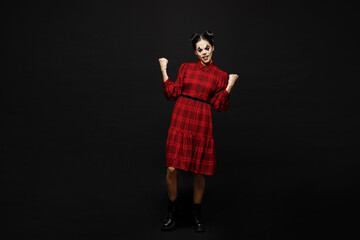 Full body young woman with Halloween makeup face art mask wear clown costume red dress do winner gesture celebrate clench fists isolated on plain black background studio. Scary holiday party concept.