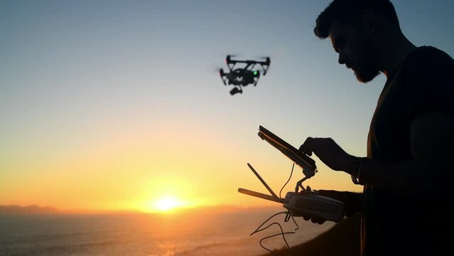 Sunset, technology and a man flying a drone over the ocean in nature for video footage during summer. Beach, sky and horizon with a person using a remote to control flight on the coast by the sea