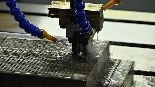 Slow motion scene the EDM machine working process with graphite electrode.