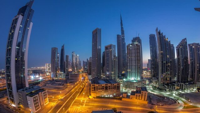 Aerial panorama of Dubai Downtown skyline with many towers night to day transition timelapse. Business area in smart urban city. Skyscrapers and high-rise buildings from above before sunrise, UAE.