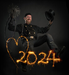 Schornsteinfeger in Arbeitskleidung springt ins Neue Jahr 2024 , Symbolbild für Jahreswechsel,...